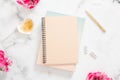 Blank paper notebook, pink flowers and golden stationery on marble background. Flat lay, top view modern home office desk. Fashion Royalty Free Stock Photo