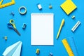 Blank paper notepad mockup with school supplies on blue background. Flat lay, top view, copy space. Back to school concept. Blue Royalty Free Stock Photo