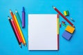 Blank paper notepad mockup with school supplies on blue background. Flat lay, top view, copy space. Back to school. Royalty Free Stock Photo