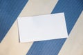 Blank paper person card lying on striped fabric. Topp view, copy space for text Royalty Free Stock Photo