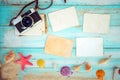 Blank paper photo frames with starfish, shells, coral and items on wooden