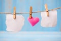 Blank paper and pink heart shape decoration hanging on line with copy space for text on blue wooden background. Love, Wedding, Royalty Free Stock Photo