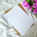 Paper for romantic letter with purple roses on the piece of white cloth Royalty Free Stock Photo