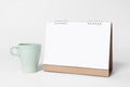 Blank paper spiral calendar for mockup template advertising and branding with cup on gray background