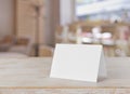 Blank paper table card on wooden table over bar background