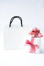 Blank paper white bag and two gift present boxes with pink ribbon on white background. Black friday sale. Shopping Royalty Free Stock Photo