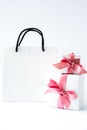 Blank paper white bag and two gift present boxes with pink ribbon on white background. Black friday sale. Shopping Royalty Free Stock Photo