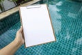 Blank paper on wood clipboard over clear swimming background