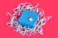 Blank pendant or medallion on a chain on closed blue jewelry box with ribbon against pink studio background. Advertising