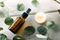 blank perfume spray bottle with eucalyptus leaves and candle on white wooden table Royalty Free Stock Photo