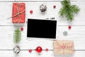 Blank photo card in frame made of fir tree branches, decorations and gift boxes Royalty Free Stock Photo