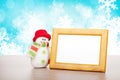 Blank photo frame and christmas snowman on wooden table Royalty Free Stock Photo