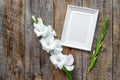 Blank photo frame near flower gladiolus on rustic wooden background top view mockup copyspace Royalty Free Stock Photo