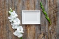 Blank photo frame near flower gladiolus on rustic wooden background top view mockup copyspace Royalty Free Stock Photo