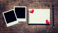 Blank photo frame, notebook, pencil and red heart on wood table