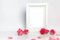 Blank photo frame and pink roses on white table background Royalty Free Stock Photo