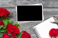 Blank photo frame with red rose flowers bouquet and lined notebook Royalty Free Stock Photo