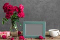 Blank photo frame and rose flowers with cup of tea and gift box on rustic wooden table. mock up. still life Royalty Free Stock Photo