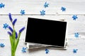Blank photo frame and spring blue flowers bouquet