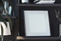 Blank photo frame on wooden shelf in stylish modern dark living room. 3d rendering. Evening