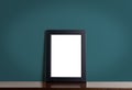 Blank photo frame on wooden table with navy wall