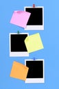 Three polaroid photo prints with post-it style office sticky notes pinned to a blue background Royalty Free Stock Photo