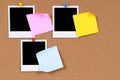 Blank polaroid photo prints with post it style sticky notes pinned to cork board, copy space Royalty Free Stock Photo