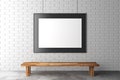 Blank picture frame on brick wall with wooden bench on concrete Royalty Free Stock Photo