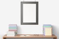 Blank picture frame hanging on a wooden table with books, mock u Royalty Free Stock Photo