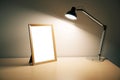 Blank picture frame with lamp on wooden table Royalty Free Stock Photo