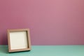 Blank picture frame on mint green table. pink wall background Royalty Free Stock Photo