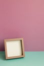 Blank picture frame on mint green table. pink wall background Royalty Free Stock Photo