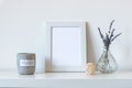 Blank picture frame next to lavender flowers in glass vase and scented candle, mock up Royalty Free Stock Photo