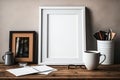 Blank picture frame on wooden table with books, cup of coffee and laptop, mock up Royalty Free Stock Photo