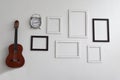 Blank picture frames, clock and guitar on white cement Royalty Free Stock Photo