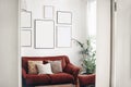 Blank picture frames mockups on white wall. White living room design. View of modern boho, scandi style interior with