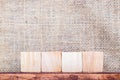 Blank 4 piece of cube wood on wood table and sack fabric wall,mock up for display your content Royalty Free Stock Photo