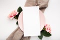 Blank piece of paper on a pink plate surrounded by roses isolated on a white background Royalty Free Stock Photo