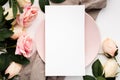 Blank piece of paper on a pink plate surrounded by roses isolated on a white background Royalty Free Stock Photo