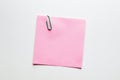 Blank pink note paper or notepad with a yellow paper clip on white background with copy space Royalty Free Stock Photo