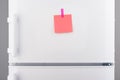 Blank pink paper note and pink sticker on white refrigerator Royalty Free Stock Photo