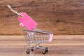 Blank pink paper price tag with shopping cart. Royalty Free Stock Photo