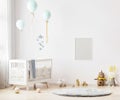 Blank poster frame mock up on white wall in nursery room interior background with baby bedding, soft toys, balloons, 3d rendering Royalty Free Stock Photo