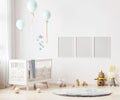 Blank poster frames mock up on white wall in nursery room interior background with baby bedding, soft toys, balloons, 3d rendering Royalty Free Stock Photo