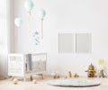Blank poster frames mock up on white wall in nursery room interior background with baby bedding, soft toys, balloons, 3d rendering Royalty Free Stock Photo