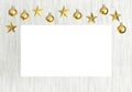 Blank poster with hanging golden balls and stars ornaments on white wooden background