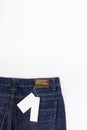 Blank Price Tag On Blue Jeans. Price tag over jeans background. Blank Tag Paper on Blue Jeans Royalty Free Stock Photo