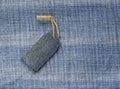 blank price tag on a rope on the background of denim for a seasonal sales Royalty Free Stock Photo