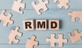 Blank puzzles and wooden cubes with the text RMD Required Minimum Distributions lie on a light blue background Royalty Free Stock Photo