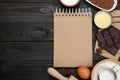 Blank recipe book and different ingredients on black wooden table, flat lay. Space for text Royalty Free Stock Photo